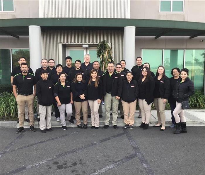 Team of SERVPRO professionals in front of a building.